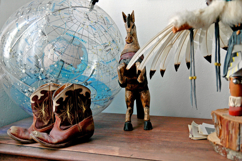 "Boots" ~ Still life of little cowboy boots, a light globe, wooden horse and a kachina doll.