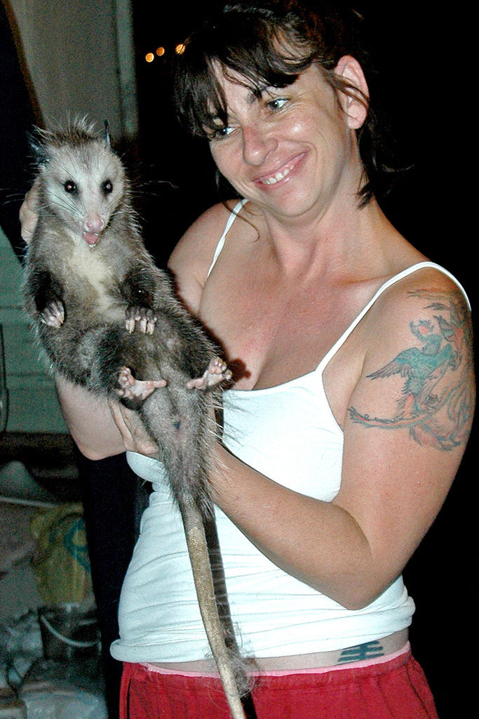 "Docile Opossum" ~ Woman holds a very calm opossum for a portrait. Photo by Ann Woodall