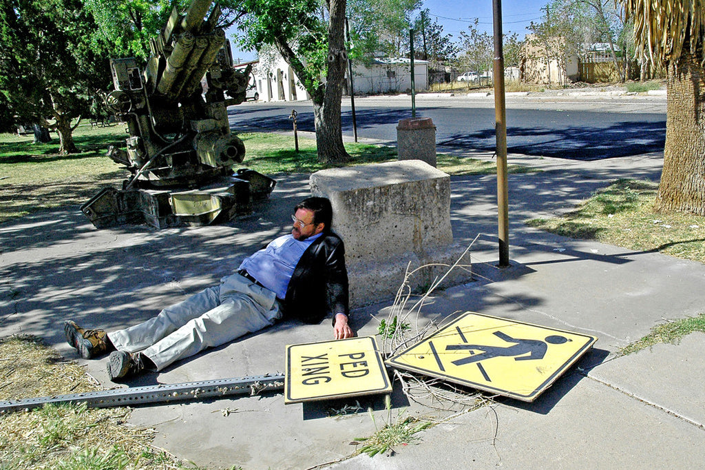 "Ped Xing" ~ A ped xing sign lies flat on the ground and my uncle John jokingly lies next to it. Photo by Ann Woodall