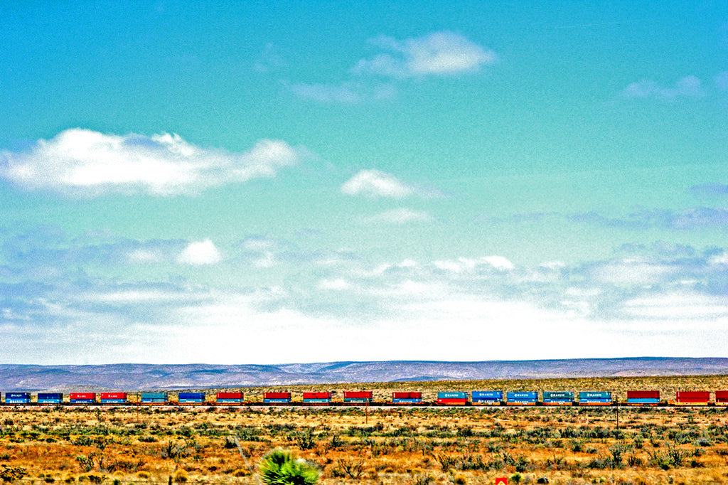 "West Texas Haul" ~ A colorful freight train in the desert set against a blue sky. Photo by Ann Woodall